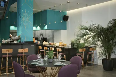 a restaurant with purple chairs and tables and a counter at The Gem Society Hotel in Athens