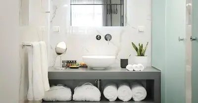 a bathroom with a counter with a sink and towels at The Gem Society Hotel in Athens