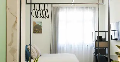 a bedroom with a bed and a mirror at The Gem Society Hotel in Athens