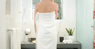 a woman in a white wedding dress standing in a bathroom at The Gem Society Hotel in Athens