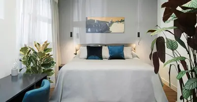 a bedroom with a bed with blue pillows at The Gem Society Hotel in Athens