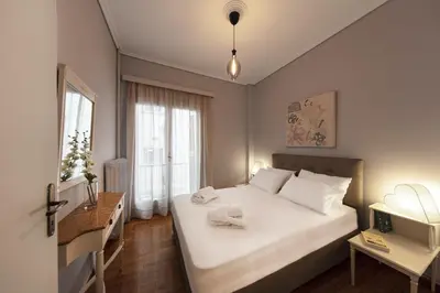 a bedroom with a large white bed and a desk at Spacious 3 Bedroom apt near Acropolis museum in Athens