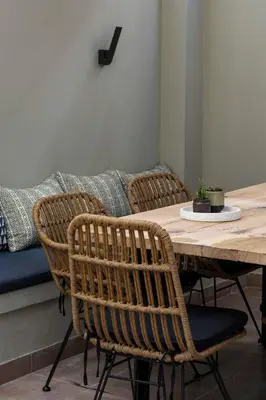 a wooden table with three chairs and a couch at “Champions” Apartment in N. Kosmos neighbourhood in Athens