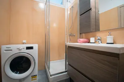 a bathroom with a washing machine and a sink at Abstract Flat With Urban View in Athens