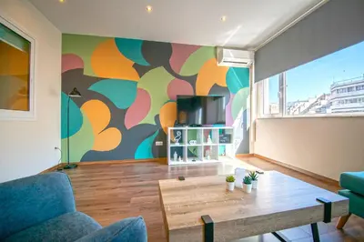 a living room with a table and a colorful wall at Abstract Flat With Urban View in Athens