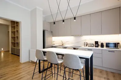 a kitchen with white cabinets and a table and chairs at The Flirty Athens apartment in Athens