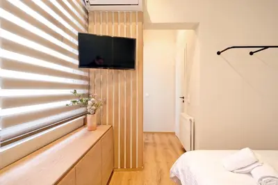 a bedroom with a tv on a wall with a window at The Flirty Athens apartment in Athens
