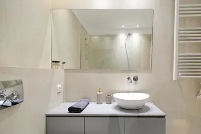 a bathroom with a white sink and a mirror at The Flirty Athens apartment in Athens