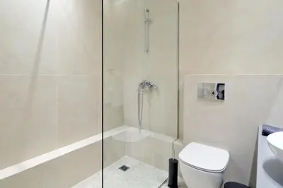 a bathroom with a shower and a toilet and a sink at The Flirty Athens apartment in Athens