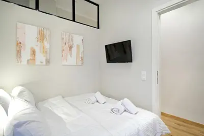 a white bedroom with a white bed with two pillows at The Flirty Athens apartment in Athens
