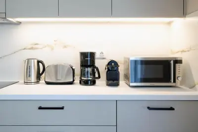 a kitchen counter with a microwave and appliances on it at The Flirty Athens apartment in Athens
