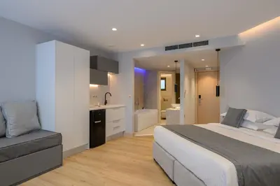 a bedroom with a large bed and a bathroom at The Convo Syngrou Apartments in Athens