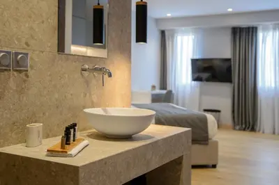 a bathroom with a bowl sink on a counter with a bed at The Convo Syngrou Apartments in Athens