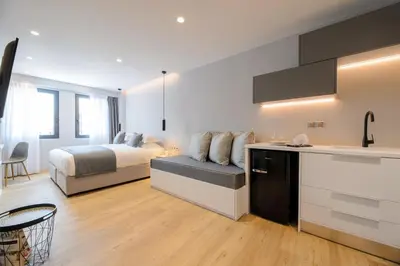 a bedroom with a bed and a kitchen with a counter at The Convo Syngrou Apartments in Athens