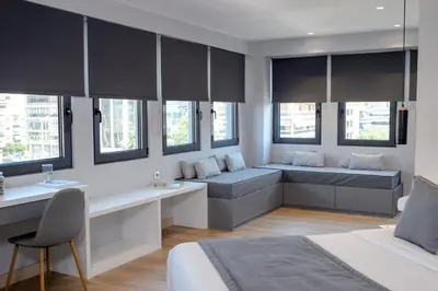 a bedroom with two beds and a desk at The Convo Syngrou Apartments in Athens