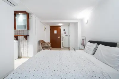 a white bedroom with a large bed in a room at Studio in the city center, Syntagma in Athens