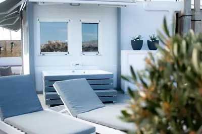 a room with two chairs and a table and windows at Private Jacuzzi & Acropolis View - The Loft in Athens