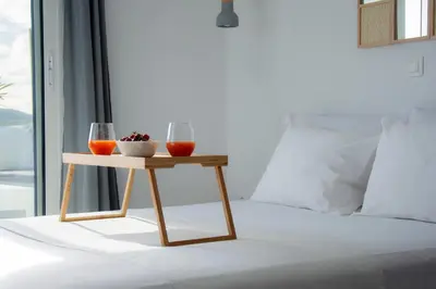 a table with two glasses of wine on a bed at Private Jacuzzi & Acropolis View - The Loft in Athens