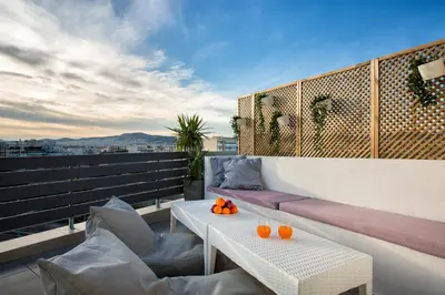 a balcony with a table and chairs on a roof at Private Jacuzzi & Acropolis View - The Loft in Athens