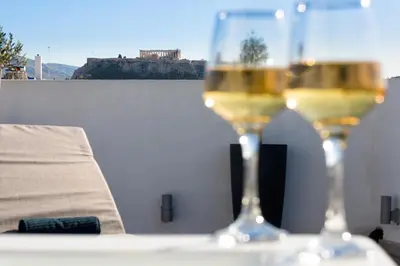 two glasses of wine sitting on top of a table at Private Jacuzzi & Acropolis View - The Loft in Athens