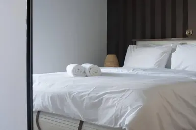 a bedroom with a white bed with towels on it at Glyfada A Modern minimal apartment in Athens