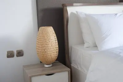a lamp on a night stand next to a bed at Glyfada A Modern minimal apartment in Athens