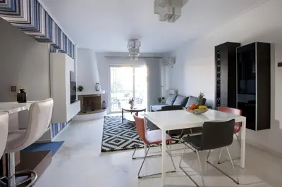 a living room with a white table and chairs at Glyfada A Modern minimal apartment in Athens