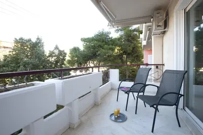 a balcony with two chairs and a table on a building at Glyfada A Modern minimal apartment in Athens