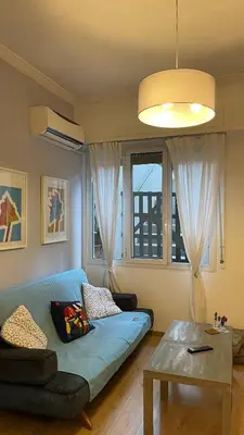 a living room with a blue couch and a table at Cozy apartment ideally located city center and Megaron Moussikis metro station in Athens