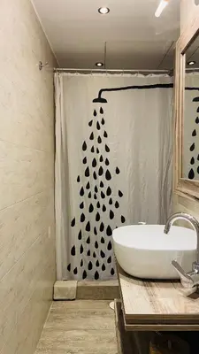 a bathroom with a shower curtain with a white sink at Cozy apartment ideally located city center and Megaron Moussikis metro station in Athens
