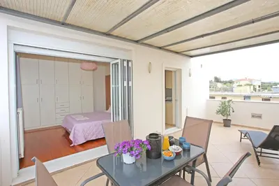 a living room with a table and chairs and a bedroom at Apartment near the Athens Airport, Spata in Spáta