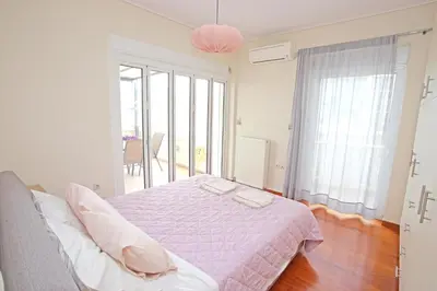 a bedroom with a bed with a purple comforter at Apartment near the Athens Airport, Spata in Spáta