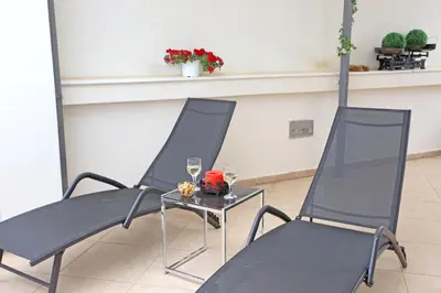 two chairs and a table with two glasses of wine at Apartment near the Athens Airport, Spata in Spáta