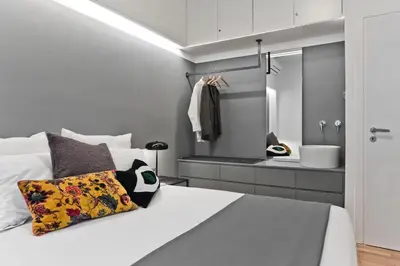 a bedroom with a bed and a bathroom with a mirror at BAG- Boutique Apartment Grey - Hilton Area in Athens