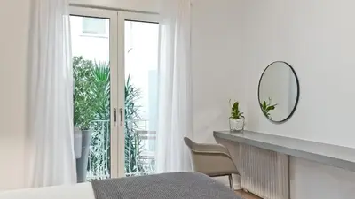 a bedroom with a bed and a mirror and a window at BAG- Boutique Apartment Grey - Hilton Area in Athens