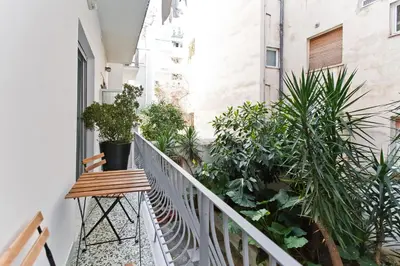 a balcony with plants and a wooden bench at BAG- Boutique Apartment Grey - Hilton Area in Athens