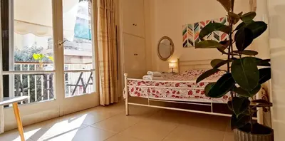 a bedroom with a bed and a large window at Next to Metro! Bright Apartment with Fully Equipped Kitchen in Athens