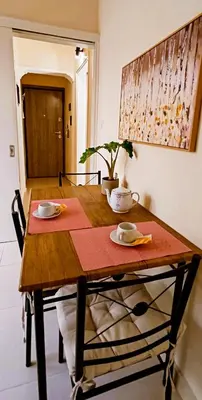 a wooden table with two plates and a plant on it at Next to Metro! Bright Apartment with Fully Equipped Kitchen in Athens