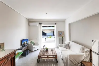 a living room with a white couch and a table at Central Halandri apartment near all hospitals in Athens