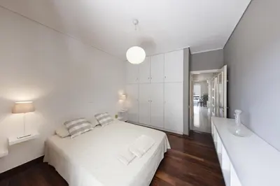 a white bedroom with a white bed and white cabinets at Central Halandri apartment near all hospitals in Athens