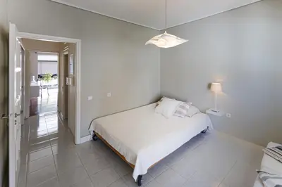 a white bedroom with a bed and a lamp at Central Halandri apartment near all hospitals in Athens