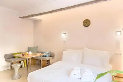 a bedroom with a white bed and a table at AM16 Suites Athens in Athens