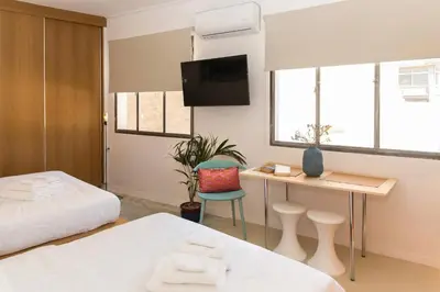 a bedroom with a bed and a desk with a tv at AM16 Suites Athens in Athens