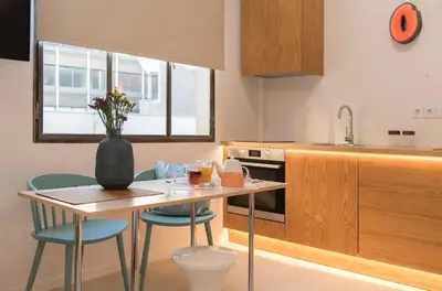 a kitchen with a table and chairs and a vase with flowers at AM16 Suites Athens in Athens