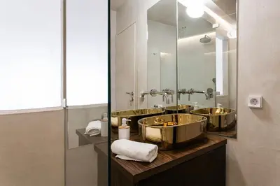 a bathroom with two copper sinks and a mirror at AM16 Suites Athens in Athens
