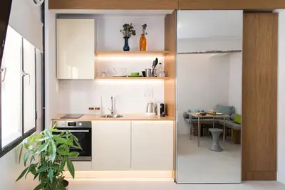 a small kitchen with white cabinets and a table at AM16 Suites Athens in Athens