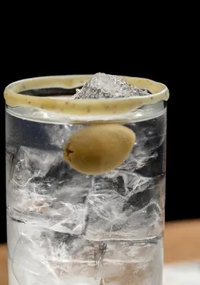 a glass of water with a green lemon in it at Belle Epoque Suites in Athens