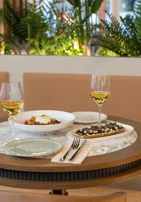 a table with two plates of food and glasses of wine at Belle Epoque Suites in Athens
