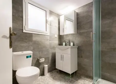 a bathroom with a toilet and a sink and a window at ATHENS Penthous at Center in Athens