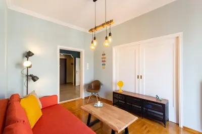 a living room with a red couch and a table at ATHENS Penthous at Center in Athens